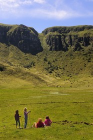 France, Cantal, France, Cantal, monts du Cantal, Parc Naturel Régional des Volcans d'Auvergne (regional nature park of Auvergne volcanoes), Puy-Mary, family of hikers at the foot of the mountain of the Fours de Peyre Arse cut by the breach of Roland