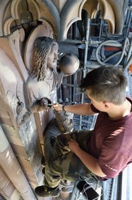 France, Bas Rhin, Strasbourg, old town listed as World Heritage by UNESCO, Notre Dame Cathedral, Judgment Day Portal Restoration Site, Christ Redeemer above King Solomon, cleaning the sculture with a toothbrush by a stonemason apprentice