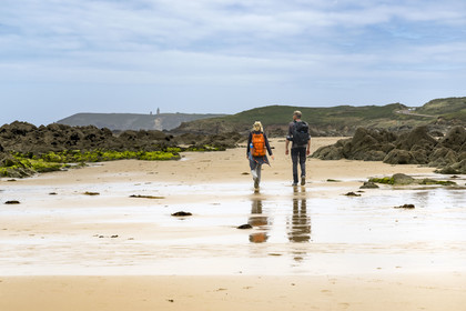 France, Côtes d'Armor (22), Grand Site de France Cap d'Erquy – Cap Fréhel, Fréhel, randonneurs sur la plage de l'Anse du Croc et le phare du Cap Fréhel en arrière plan