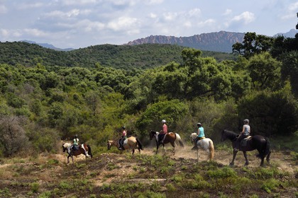 France, Var, Agay area next to Saint-Raphael, riders trekking in the Massif de l'Esterel (Esterel Massif) and the rastel of Agay in the background