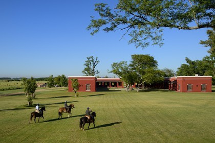 Argentina, Buenos Aires Province, San Antonio de Areco, estancia La Bamba de Areco, gauchos on horseback in front of the stables for polo horses