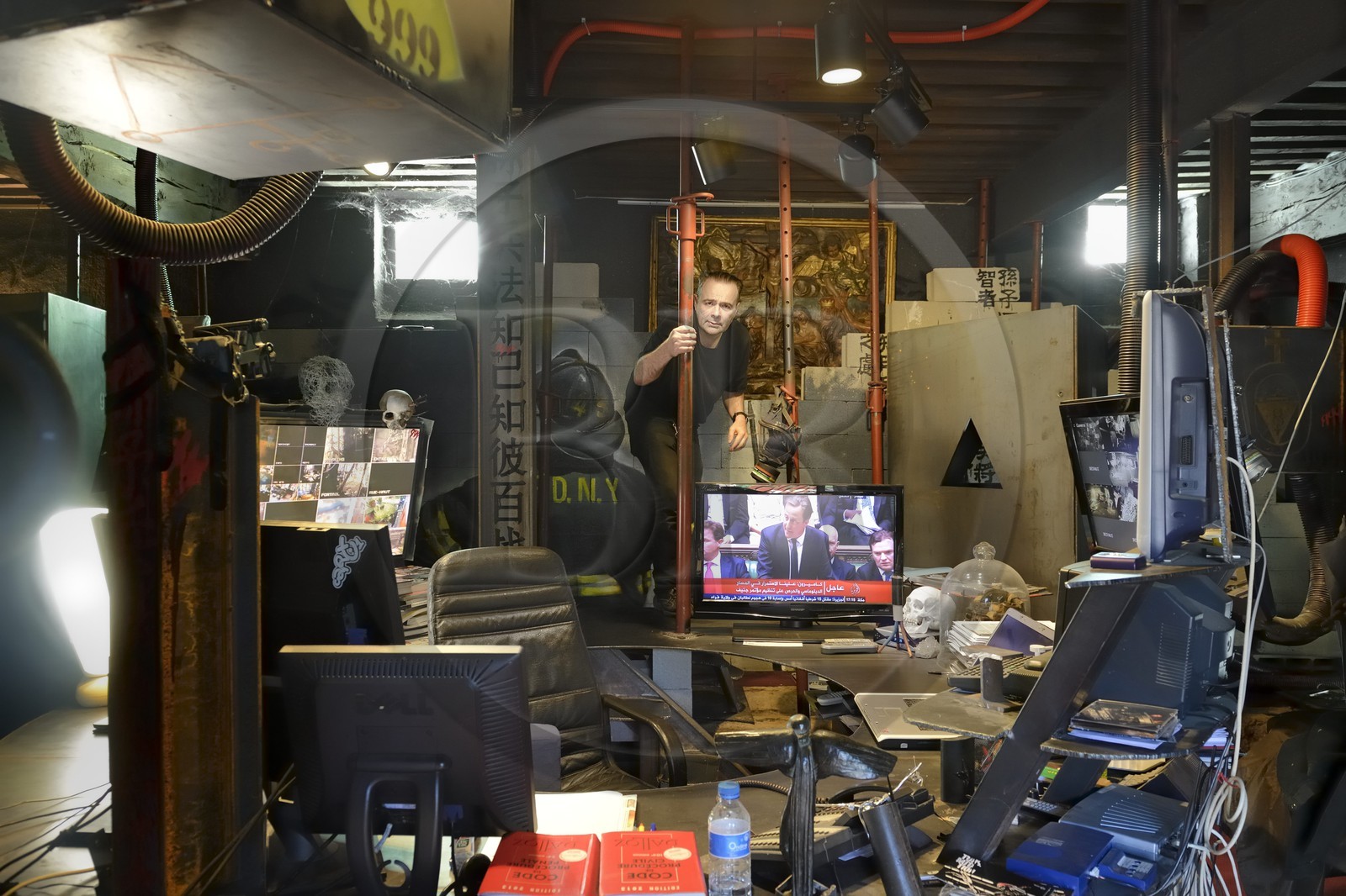 France, Rhône (69), Saint-Romain-au-Mont-d'Or, la Demeure du Chaos, l'œuvre d'art est basé sur la transformation sans fin de la maison du XVIIème siècle de l'artiste plasticien Thierry Ehrmann en une réplique de zone de guerre à l'image du monde présent, portrait de Thierry Ehrmann, aussi président fondateur de Artprice et du Groupe Serveur, sur son bureau