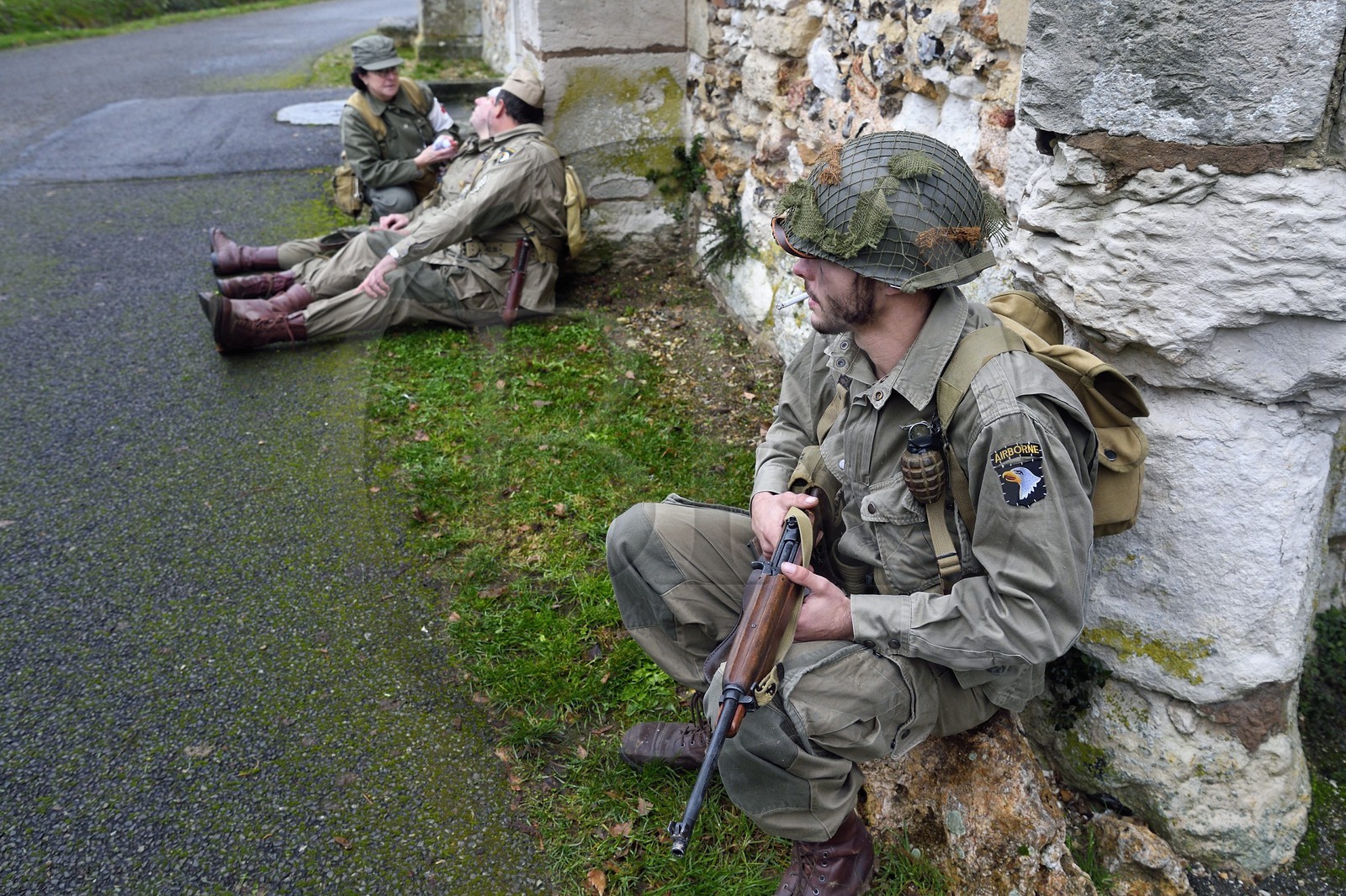 France, Eure (27), Chambray, Allied Reconstitution Group (association de reconstitution historique de la 2éme Guerre Mondiale US et Maquis), reconstitueurs en uniforme de la 101e division aéroportée US au repos devant l'église