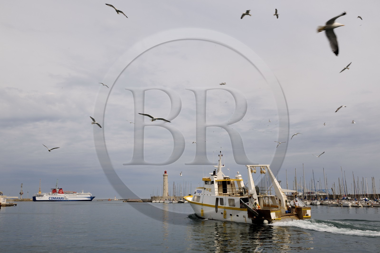 France, Hérault (34), Sète, Vieux Port, retour de pêche d'un chalutier et le phare du Môle Saint-Louis