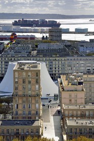 France, Seine Maritime, Le Havre, Downtown rebuilt by Auguste Perret listed as World Heritage by UNESCO, Perret buildings around the cultural center called Volcano created by Oscar Niemeyer, a container ship in the background leaves the commercial port