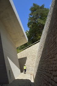 France, Dordogne (24), Montignac, chantier du futur Centre International de l'Art pariétal de Montignac-Lascaux (Lascaux 4) conçu par l'agence norvégienne d'architecture Snøhetta, chemin d'accès à la reconstitution de la grotte par une longue tranchée en pente en lisière de forêt et faite de béton et de pierres du pays