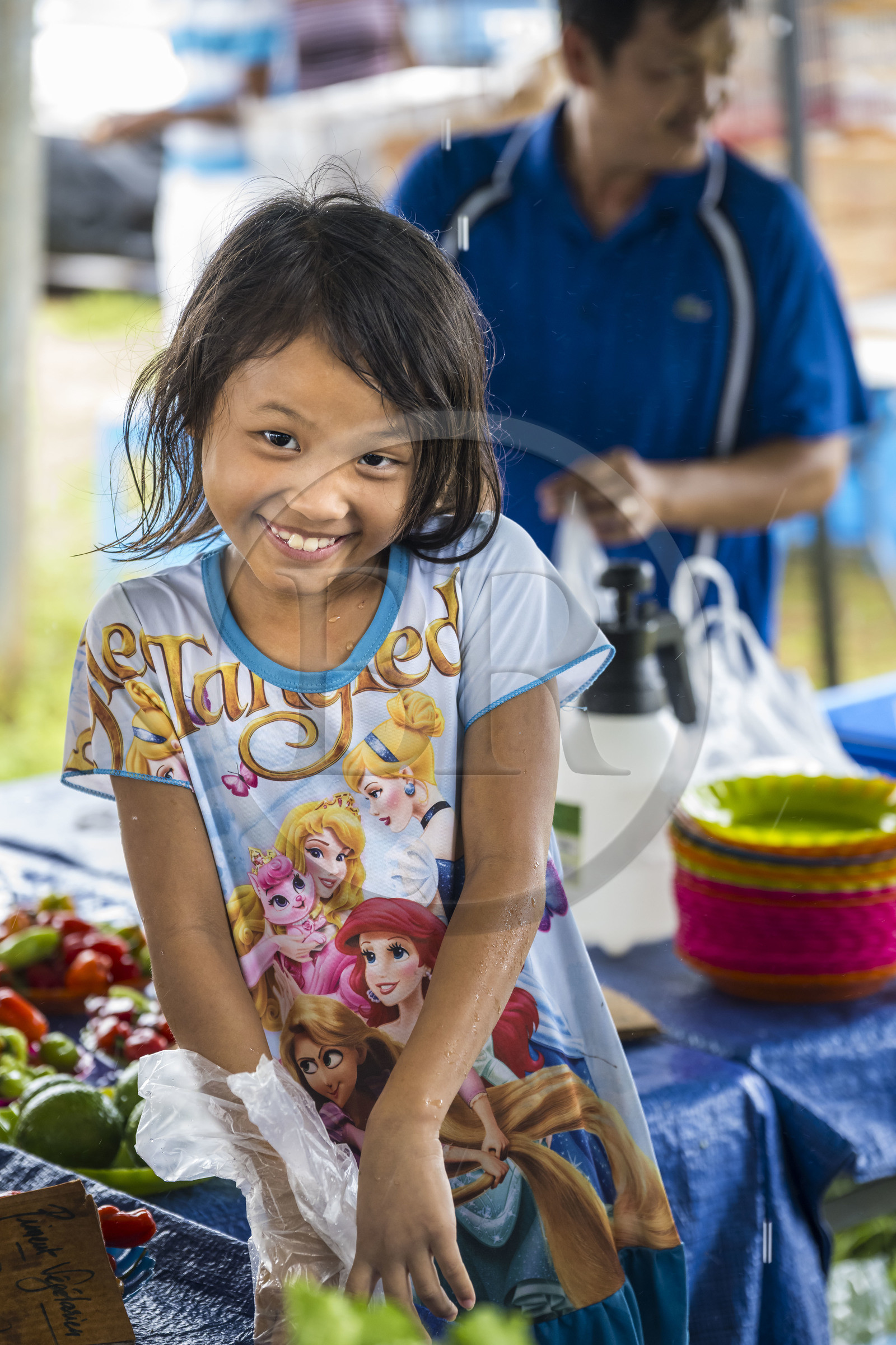 France, Guyane, Javouhey, marché du dimanche Hmong, réfugiés du Laos arrivés en 1978 qui se sont spécialisés dans la culture fruitière, Nancy, 7 ans, présente les produits de l'étal de ses parents