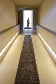 France, Dordogne (24), Périgord Noir, vallée de la Vézère, Les Eyzies-de-Tayac-Sireuil, site classé Patrimoine Mondial de l'UNESCO, Musée National de la Préhistoire, moulage des pas de Laetoli découverts sur un site tanzanien en 1976, traces de pas humains conservés depuis 3,5 millions d’années dans des boues durcies recouvertes de cendres volcaniques, en arrière plan l’adolescent du Lac Turkana (Nariokotome Boy)