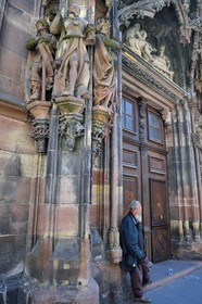 France, Bas Rhin, Strasbourg, old town listed as World Heritage by UNESCO, Notre Dame Cathedral, portal of Saint-Laurent in the north transept with the adoration of the biblical magi by sculptor Johan von Ach, beggar waiting for the exit of the mass