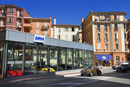 Principality of Monaco, Monaco, La Condamine district, luxury cars in the window of a used car seller and Volkswagen Beetle