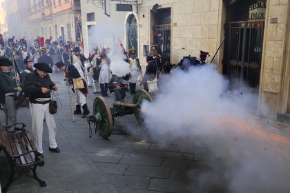 Italy, Liguria, Sarzana, Piazza Matteotti, Napoleon Festival, french soldiers of the Grande Armée firing the cannon on the austrian enemy in the main street Via Mazzini in the old town