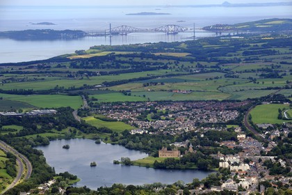 Royaume-Uni, Ecosse, West Lothian, le Linlithgow Palace à côté du Loch Linlithgow était l'une des principales résidences des rois d'Écosse dans les XVème et XVIème siècles et lieu de naissance de Mary Stuart, et le Forth railway bridge (pont ferroviaire de Forth) en arrière plan (vue aérienne)