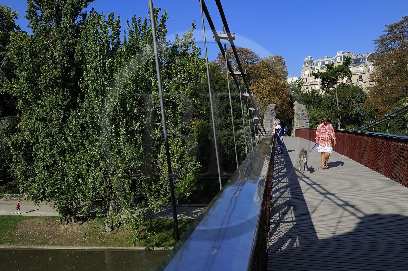 France, Paris, Buttes Chaumont park, the bridge and the Haussmann style buildings of the Manin street