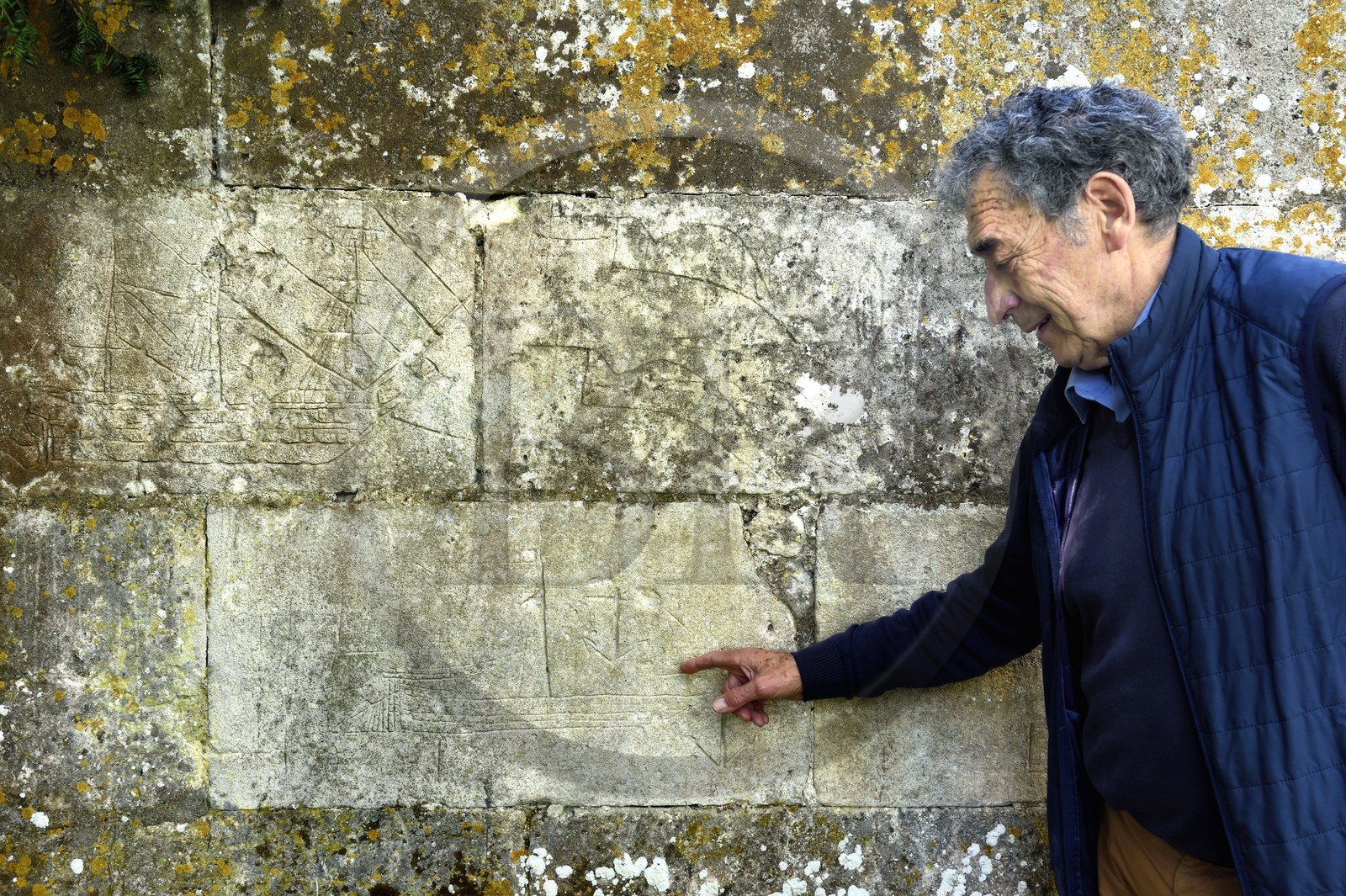 France, Charente (16), Saint-Simon, le maire du village gabarrier Jean Jacques Delage devant un plan de gabarre gravé sur un mur du port de Juac, en haut à gauche on peut voir un graffiti d'un bateau à voile de la Royale