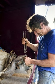 France, Ardeche, parc naturel regional des Monts d'Ardeche (Regional natural reserve of the Mounts of Ardeche), Mezenc Massif, Lac d'Issarles, Ferme de La Louvèche, farrier Olivier Rieu works a horseshoe in his traveling workshop