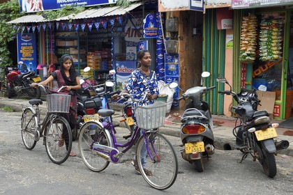Sri Lanka, Eastern Province, Trincomalee, girls on bicycles in front of shops in the main street
