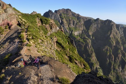 Portugal, Ile de Madère, randonneurs sur le sentier du Vereda do Areeiro entre les monts Pico Ruivo (1862m) et Pico Arieiro (1817m), vue depuis le Pico Arieiro sur la chaine de montagnes centrale et le belvédère de Ninho da Manta (nid de buse) en arrière plan