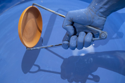 France, Nièvre, Nevers, Fayencerie d’art de Nevers, master earthenware maker Clair Bernard dips the biscuit using a metal claw into the Bleu de Nevers enamel bath