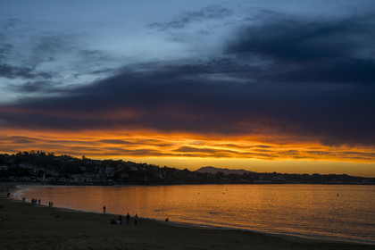 France, Pyrenees Atlantiques, Basque Country, Saint Jean de Luz, walkers on the Grande Plage and the coast of Ciboure in the bay in the background