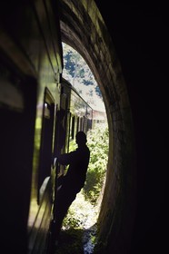 Sri Lanka, Province d'Uva, trajet en train dans la région montagneuse de la culture du thé entre Badulla et Ella, passager accrochés aux portières sous un tunnel