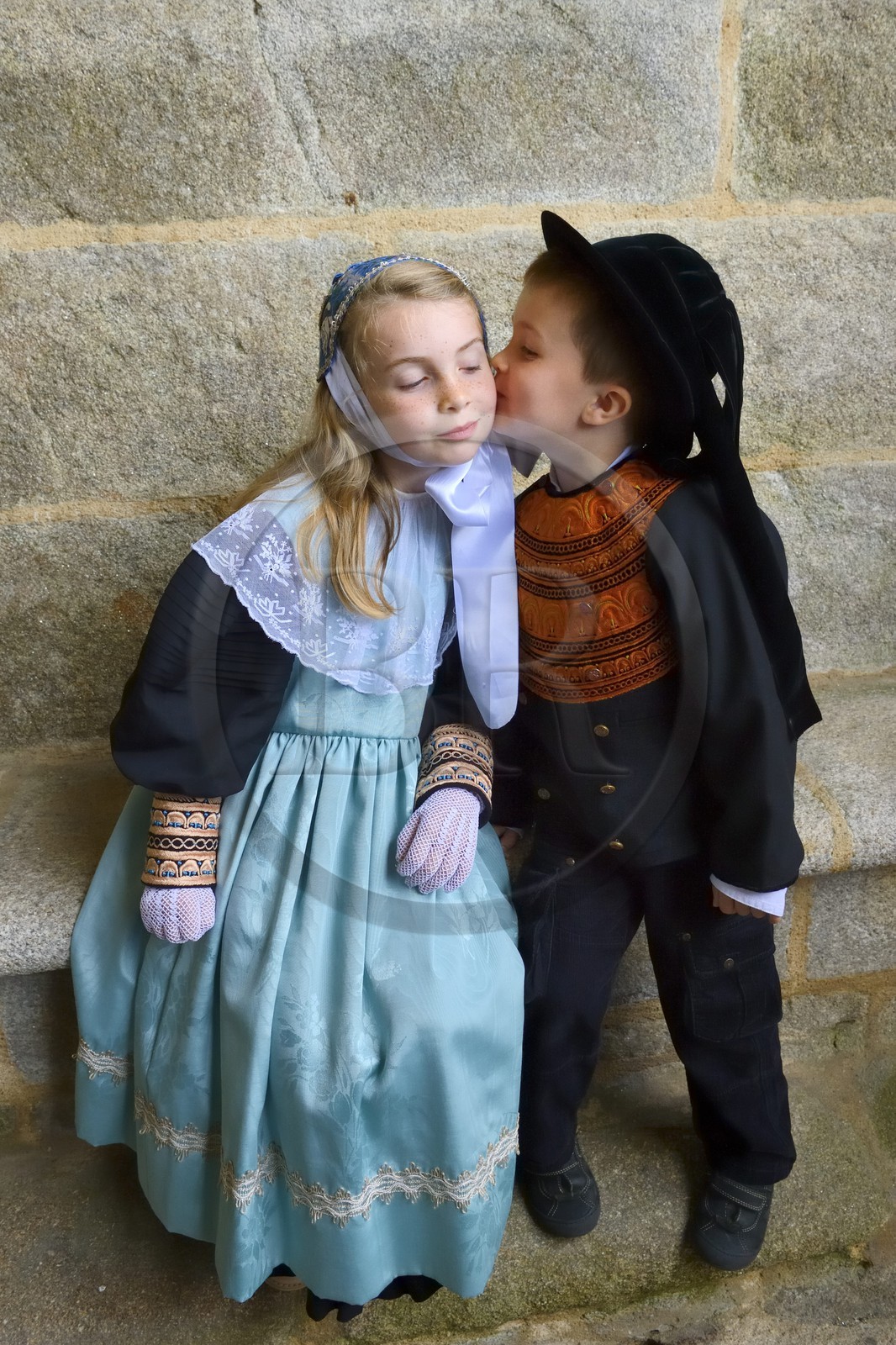 France, Finistère (29), Locronan, labellisé Les Plus Beaux Villages de France, baiser d'enfants en costumes traditionnels sous le porche de l'église Saint-Ronan le jour de la procession de la Troménie