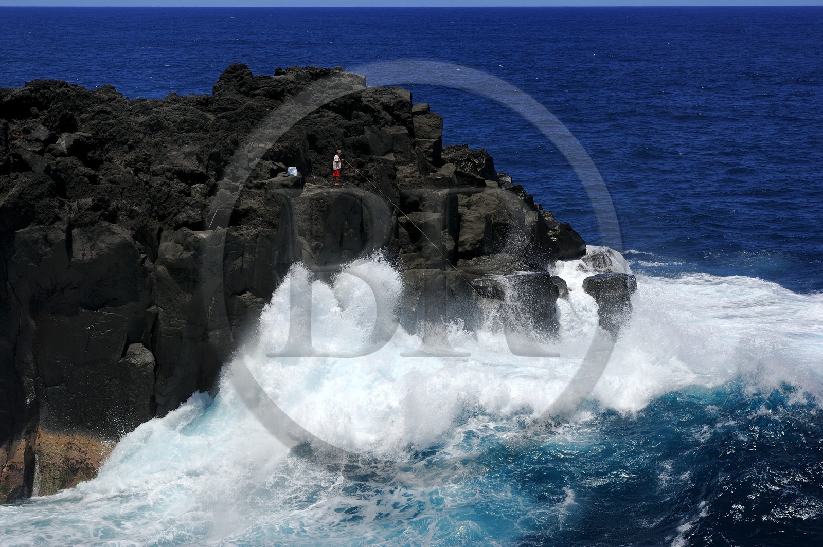 France, Ile de la Reunion, côte sud, Saint-Philippe, le Cap Méchant est situé le long d'une côte déchiquetée de roche volcanique frappée par la houle et typique de la région appelée Sud sauvage, pêcheur sur un rocher