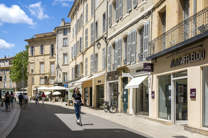 France, Bouches du Rhone, Aix en Provence, rue Thiers, woman on an electric scooter