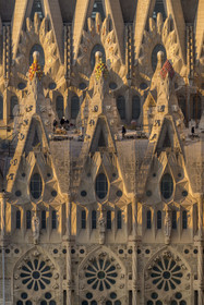 Spain, Catalonia, Barcelona, Eixample district, Sagrada Familia basilica by Catalan modernist architect Antoni Gaudi, listed as a UNESCO World Heritage Site, peaks topped with mosaics in the shape of fruits surrounding the construction site on the roof of the nave here on the Passion facade side