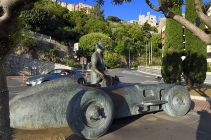Principality of Monaco, Monaco,  Juan Manuel Fangio sculpture by Catalan artist Joaquim Ros Sabaté on the port and the royal palace on the Rock