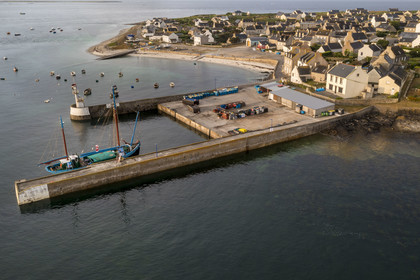 France, Finistère, Iroise Sea, Molene archipelago, Molene Island, the town and the ship Notre-Dame de Rumengol former barge at the quayside in the port (aerial view)