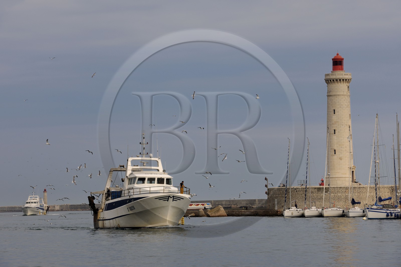 France, Hérault (34), Sète, Vieux Port, retour de pêche d'un chalutier et le phare du Môle Saint-Louis