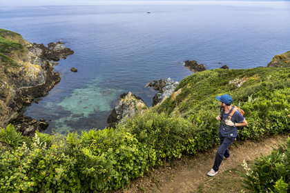 France, Morbihan, Groix Island, the Pointe de Pen-Men nature reserve, hiker on the coastal path