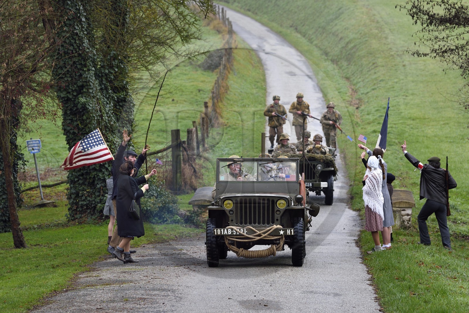France, Eure (27), Sainte-Colombe-prés-Vernon, Allied Reconstitution Group (association de reconstitution historique de la 2éme Guerre Mondiale américain et Maquis), reconstitueurs en uniforme de la 101e division aéroportée US progressant en jeep Willys accueillis en libérateurs par des villageois et FFI