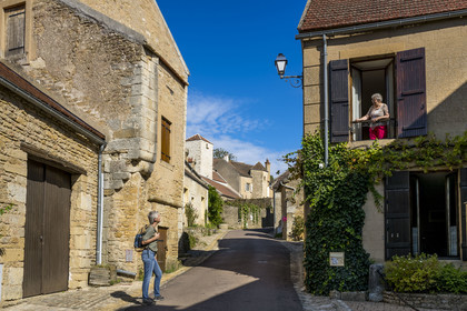 France, Yonne, Montreal (Burgundy), a hiker talks with Geneviève Honig, writer and memory of the village, in the Grand-Rue