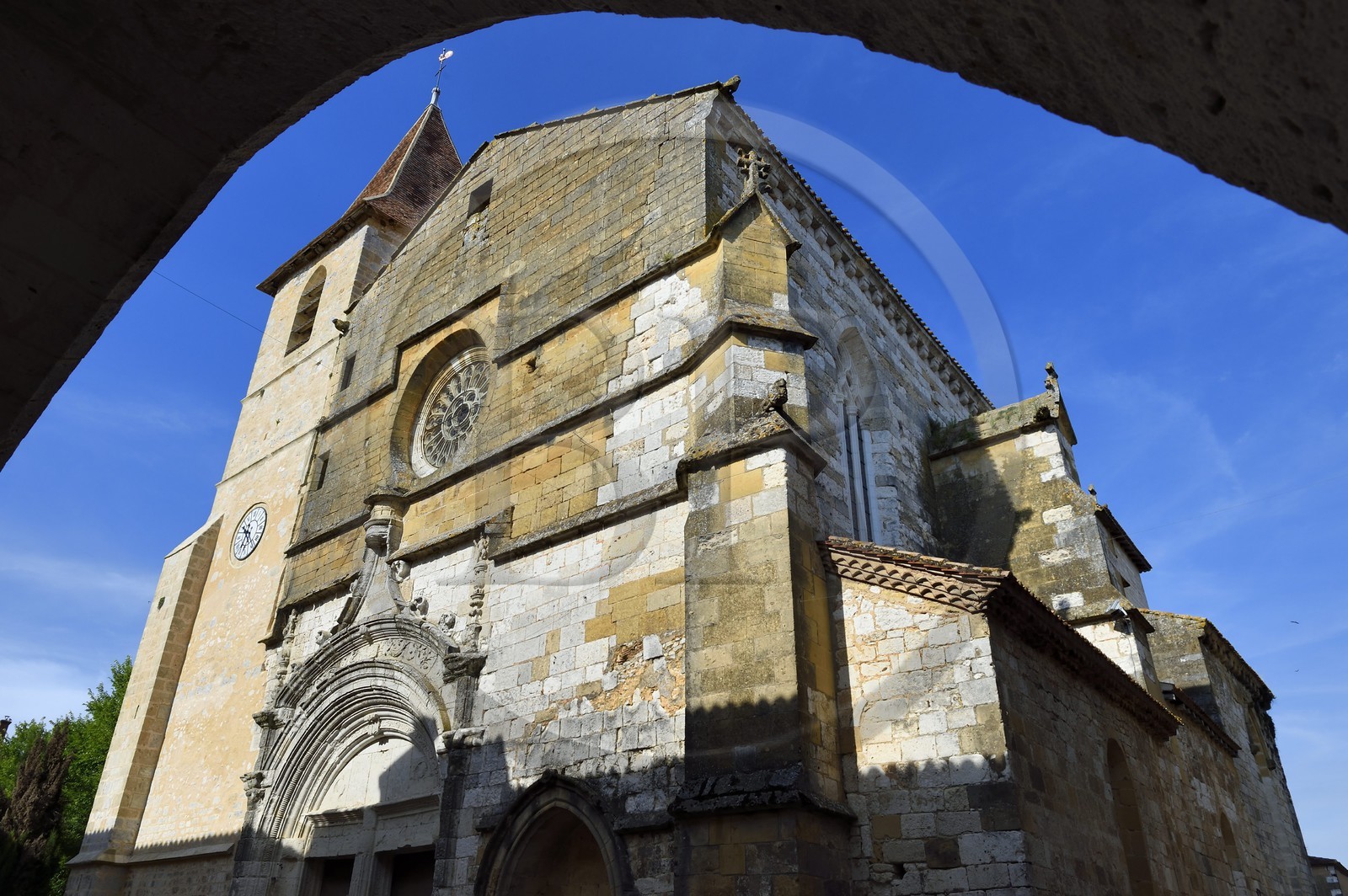 France, Dordogne (24), Périgord Pourpre, Monpazier, labellisé Les Plus Beaux Villages de France, facade occidentale de l'église Saint-Dominique vue d'une arcade de la place des Cornières au coeur du village
