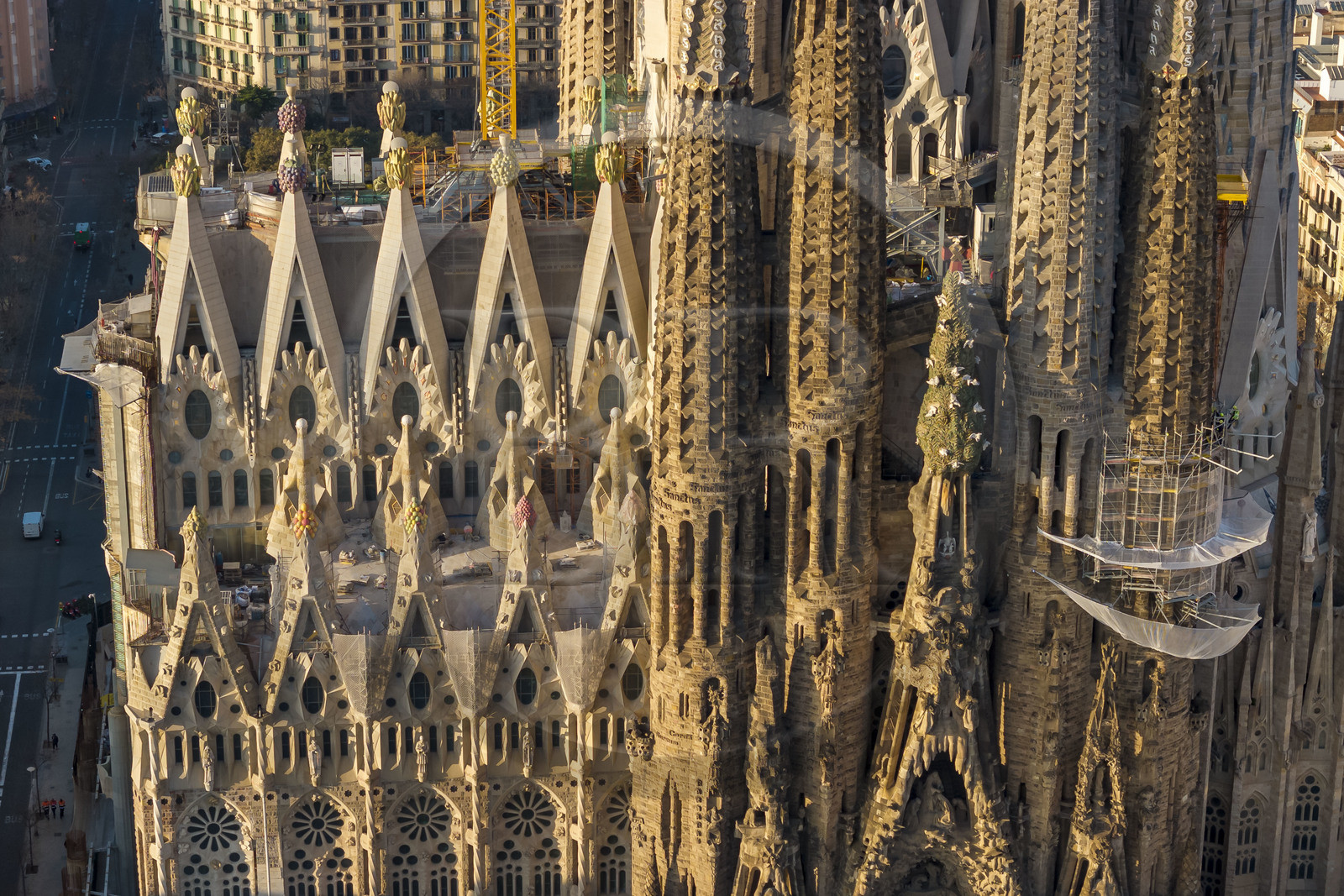 Espagne, Catalogne, Barcelone, quartier de l'Eixample, basilique de la Sagrada Familia de l'architecte du modernisme catalan Antoni Gaudi classée Patrimoine Mondial de l'UNESCO, sommets surmontés de mosaïques en forme de fruits entourant le chantier sur le toit de la nef ici côté facade de la Passion