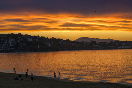 France, Pyrenees Atlantiques, Basque Country, Saint Jean de Luz, walkers on the Grande Plage, the coast of Ciboure in the bay and the Spanish mount Jaizkibel in the background