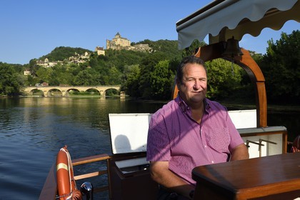 France, Dordogne, Perigord Noir, Dordogne Valley, gabare (flat-bottomed boat) on the Dordogne river upstream Castelnaud la Chapelle, Michel Léger director of the Gabares Norbert