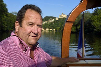 France, Dordogne, Perigord Noir, Dordogne Valley, gabare (flat-bottomed boat) on the Dordogne river upstream Castelnaud la Chapelle, Michel Léger director of the Gabares Norbert