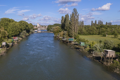 France, Charente-Maritime, Saintonge, Saint-Savinien, labeled stones and water villages, fishing huts with a net along the Charente river  and the village in the background (aerial view)
