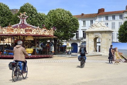 France, Charente-Maritime, Rochefort, cyclists traveling along La Flow Vélo cycle route on Place Colbert with its monumental fountain