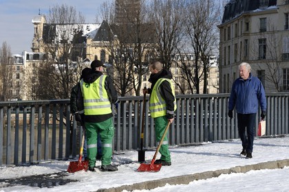 France, Paris, Pont Saint-Louis, men from the service of the Propreté de Paris (Paris cleanliness) clearing the snow on the sidewalks