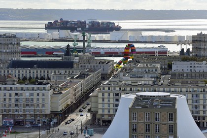 France, Seine Maritime, Le Havre, Downtown rebuilt by Auguste Perret listed as World Heritage by UNESCO, Perret buildings around the cultural center called Volcano created by Oscar Niemeyer, a container ship in the background leaves the commercial port