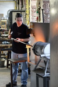 France, Moselle (57), Meisenthal, Centre international d’Art verrier (CIAV), l'atelier de soufflage, fabrication artisanale d'une boule de Noël, le souffleur recueille dans le four une masse de verre en fusion avec sa canne de verrier
