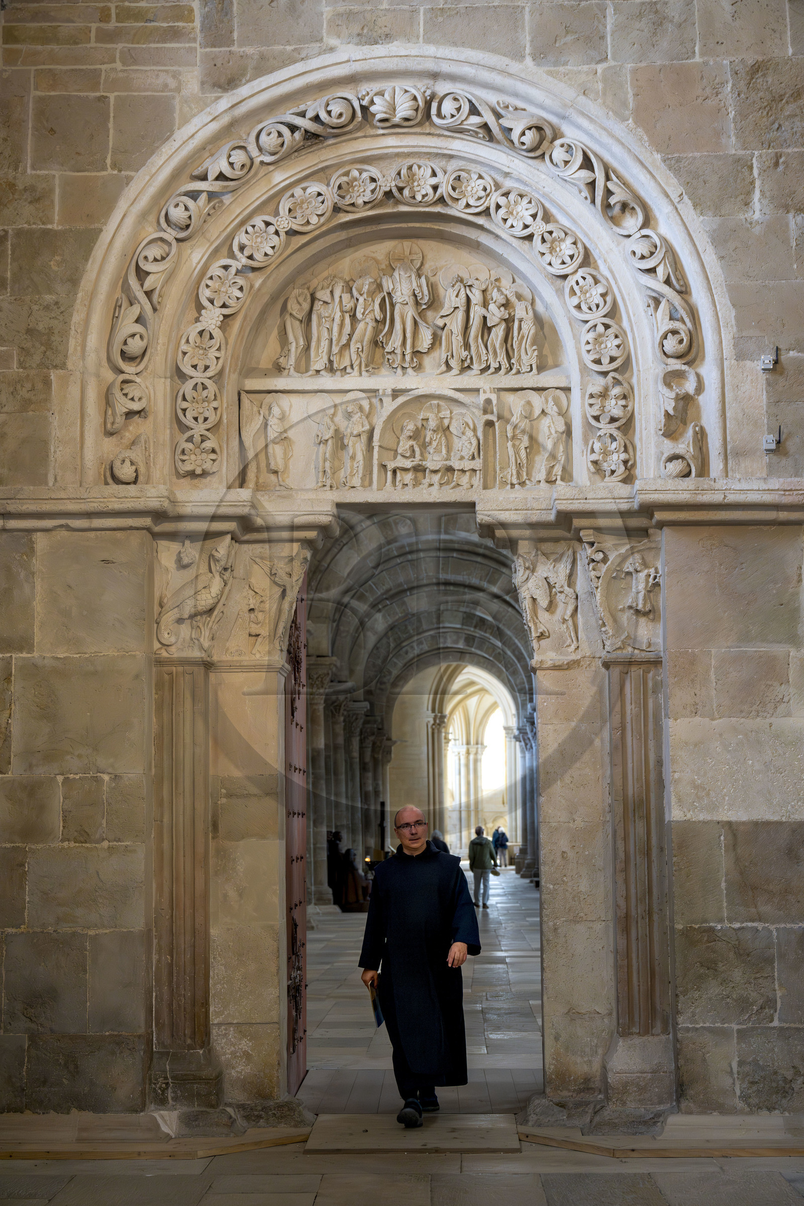 France, Yonne (89), parc naturel régional du Morvan, Vézelay, classé au Patrimoine Mondial de l'UNESCO, labellisé Les Plus Beaux Villages de France, point de départ de l'une des principales voies de pèlerinage de Saint-Jacques-de-Compostelle, la basilique Sainte-Marie-Madeleine, le portail lateral dans le narthex, le frère Matteo en tunique et chasuble noir fait partie de la Fraternité de Jérusalem
