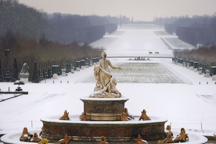 France, Yvelines, snow covered park of the Chateau de Versailles, listed as World Heritage by UNESCO, the Latona Basin and gardens perspective and the Axe du Soleil (the Sun Axis) to the frozen Grand Canal