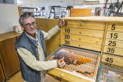 France, Hérault (34), Lodève, Manufacture de la Savonnerie unique annexe de la Manufacture Nationale de tapis de la Savonnerie des Gobelins, le directeur du site Jean-Marc Sauvier devant le nuancier NIMES qui contient les pompons de laine échantillons