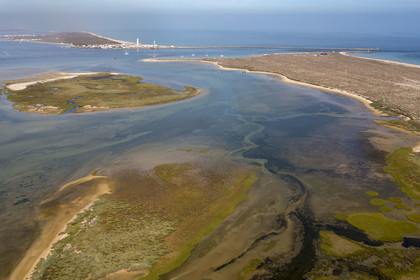 Portugal, Algarve, Ria Formosa Natural Park, Faro, Island of Barreta or Deserta (Ilha da Barretta or Deserta), the lighthouse of Ilha do Farol part of  Ilha da Culatra in the background (aerial view)