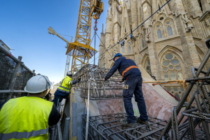 Spain, Catalonia, Barcelona, Eixample district, Sagrada Familia basilica by Catalan modernist architect Antoni Gaudi, listed as a UNESCO World Heritage Site, cloister construction site under the facade of the apse, largely still in neo-gothic style with its animal-shaped gargoyles, installation of reinforced concrete frame