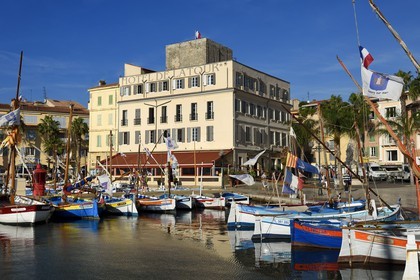 France, Var, Sanary-sur-Mer, traditional fishing boats called pointus in the port, Hotel de la Tour that wraps the Romanesque 13th century tower in the background